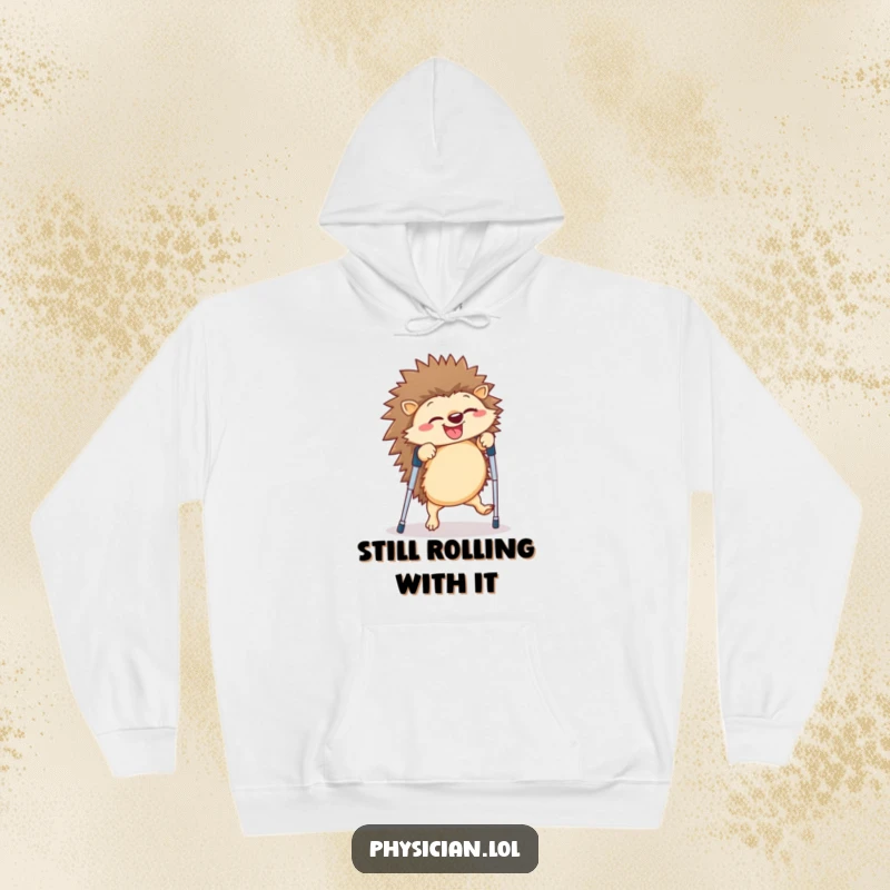 Funny hedgehog hoodie showing a giggling creature attempting a cartwheel on crutches, a humorous depiction of overcoming challenges with a smile.
